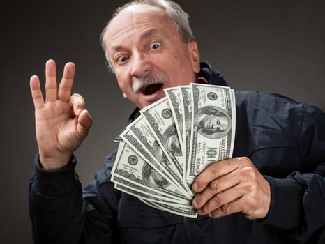 Happy elderly man showing fan of money photo