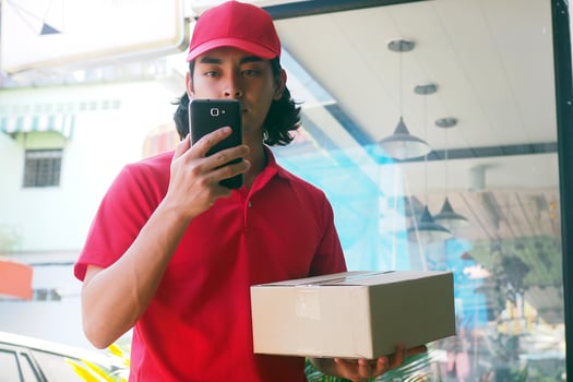 The young man sent the product to find the customer information via the smartphone. Fast delivery photo