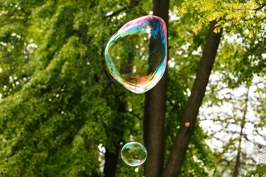 Close up of flying soap bubble with great reflections. Flying over green background photo