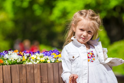 Little adorable girl with flowers in tulips garden photo