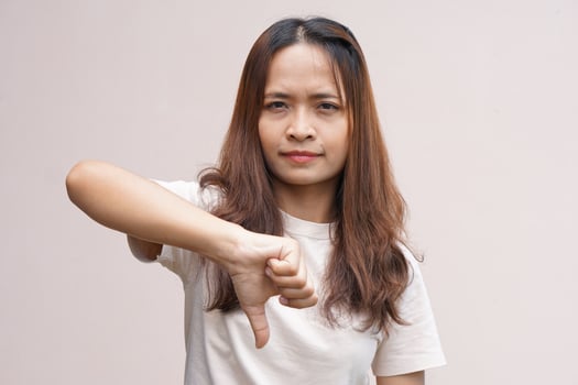 Asian woman's hand raising thumbs as a sign of dislike photo