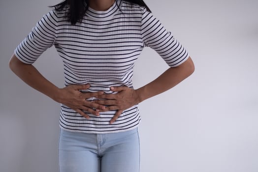 Women touch abdomen with severe abdominal pain or diarrhea. The concept of stomach cramps, diarrhea photo
