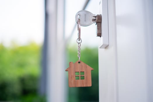 House key with a house key, made of wood in the keyhole ready to sell the concept of real estate. photo
