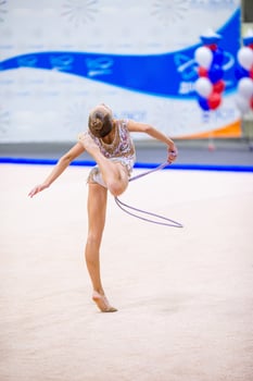 Beautiful little active gymnast girl with her performance on the carpet photo