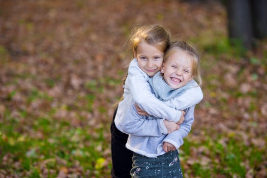 Little adorable girls at warm day in autumn park outdoors photo