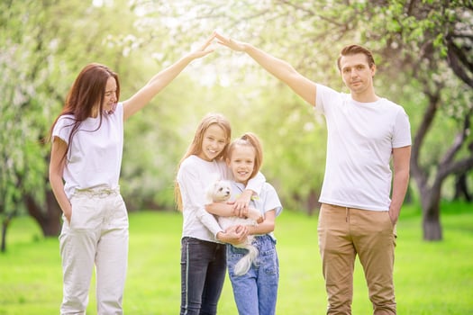 Adorable family in blooming cherry garden on beautiful spring day photo