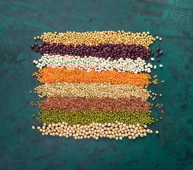 Square of superfoods laid out stripes, in middle of textured emerald green background. photo