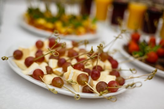 Refined appetizer of cheese fruits and berries pieces of cheese with pricked skewers berries photo