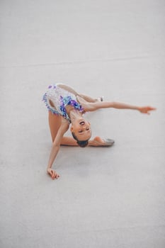 Beautiful little active gymnast girl with her performance on the carpet photo