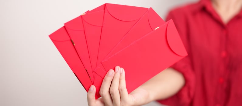 Woman holding Chinese red envelope, money gift for happy Lunar New Year holiday photo
