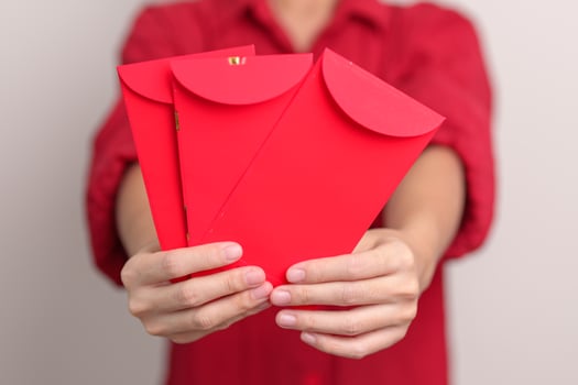 Woman holding Chinese red envelope, money gift for happy Lunar New Year holiday photo