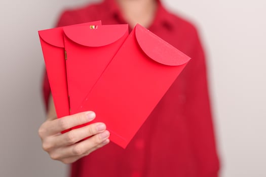 Woman holding Chinese red envelope, money gift for happy Lunar New Year holiday photo