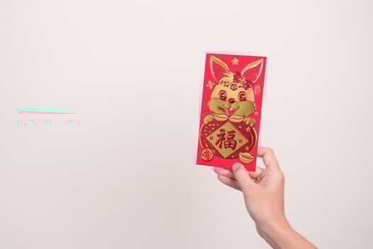 woman holding Chinese red envelope with golden rabbit and blessing word, money gift for happy Lunar New Year holiday. Chinese sentence means happiness, healthy, Lucky and Wealthy photo