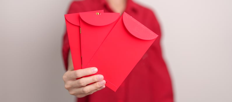 Woman holding Chinese red envelope, money gift for happy Lunar New Year holiday photo
