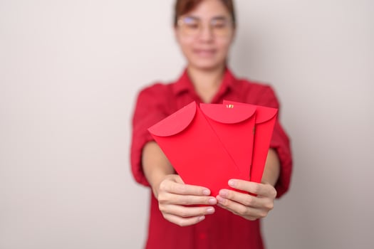 Woman holding Chinese red envelope, money gift for happy Lunar New Year holiday photo