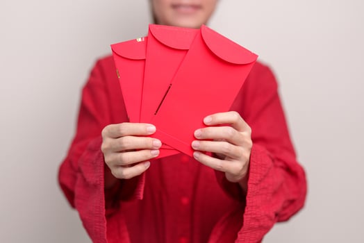 Woman holding Chinese red envelope, money gift for happy Lunar New Year holiday photo