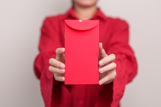 Woman holding Chinese red envelope, money gift for happy Lunar New Year holiday photo