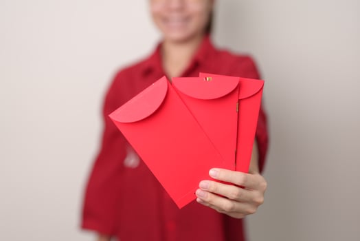 Woman holding Chinese red envelope, money gift for happy Lunar New Year holiday photo
