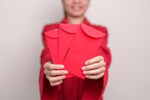 Woman holding Chinese red envelope, money gift for happy Lunar New Year holiday photo
