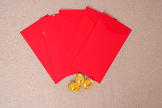 Chinese red envelope with gold bullion, money gift for happy Lunar New Year holiday. Chinese sentence means happiness, healthy, Lucky and Wealthy photo