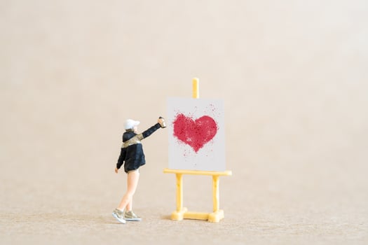 Artist holding dispenser and spraying with red heart shapes, Valentine day concept photo