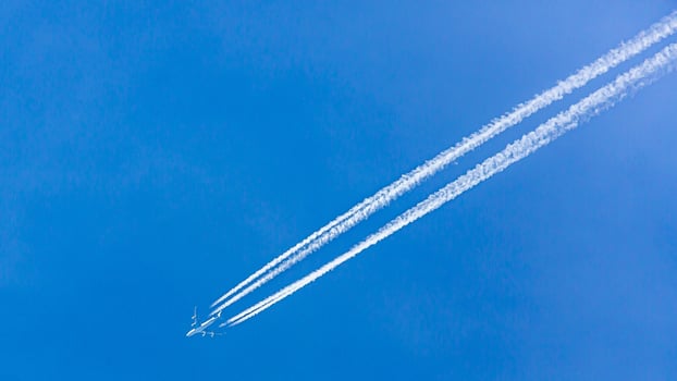 Four engined airplane during flight in high altitude with condensation trails photo