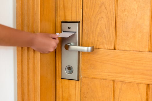 Female hand putting and holding magnetic key card switch in to open hotel room door photo
