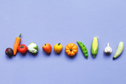 many vegetables and fruits on purple background. healthy food concept photo