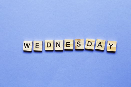 inscription wednesday made by wooden cubes on a veri peri purple background. photo
