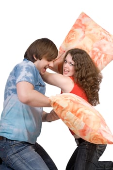 The young couple fights pillows. Isolated photo