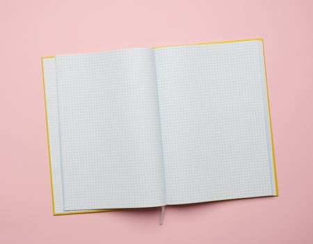 open notepad with empty white sheets on a pink background photo