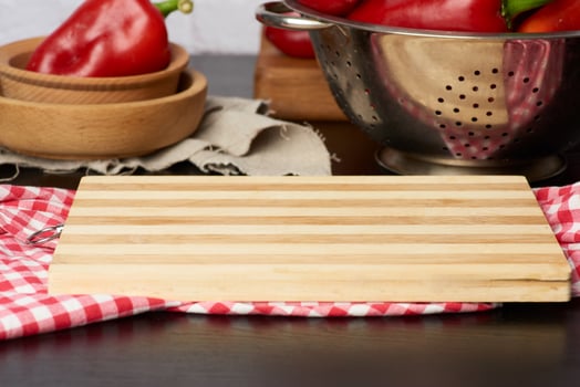brown rectangular wooden kitchen cutting board and red napkin on the table photo