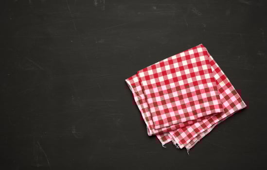 red-white textile kitchen towel on a black wooden background photo