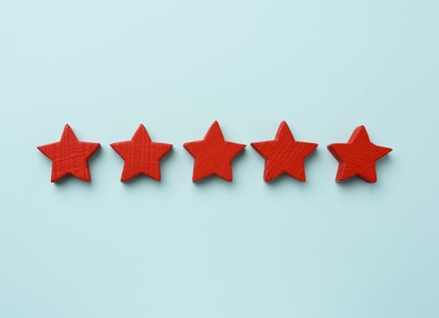 five red wooden stars on a blue background, high score photo