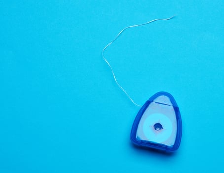 blue plastic packaging with dental floss on a blue background photo
