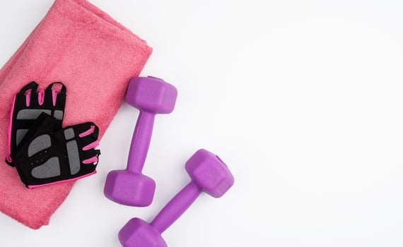 gloves, pair of purple dumbbells and pink towel on a white background photo