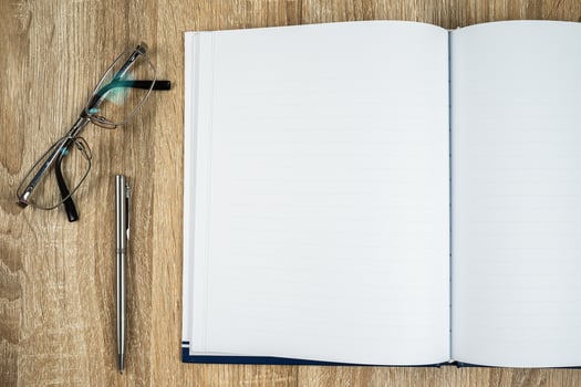 Blank notebook diary with silver pen and glasses photo