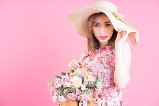 Photo of young Asian girl wearing flower dress on pink background
