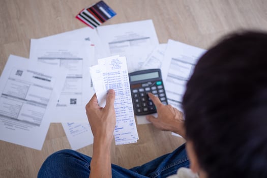 Asian man are stressed about financial problems. With invoices and various bills and calculators placed while having problems with home expenses. debt concept photo
