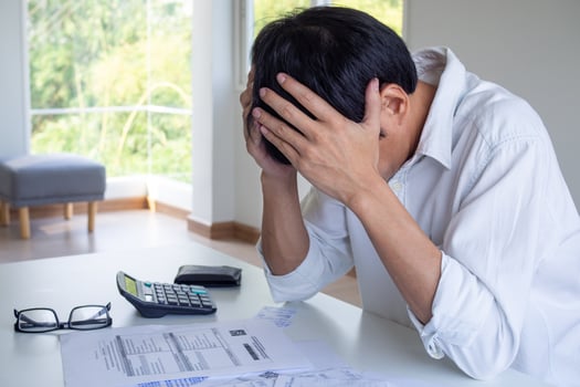 The man is sitting stressed about the debt that is time to pay. Worried about the monthly expenses bill placed on the table. photo