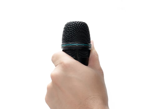 Hand holding a microphone isolated on white background photo