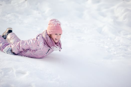 Adorable little happy girl sledding in winter snowy day. photo