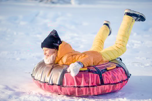 Adorable little happy girl sledding in winter snowy day. photo