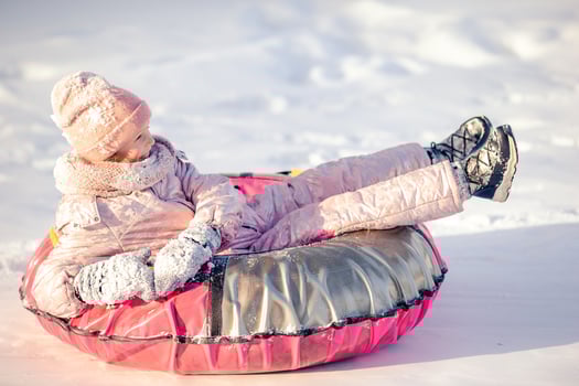 Adorable little happy girl sledding in winter snowy day. photo