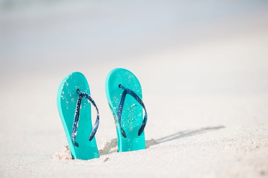Summer mint flip flops with sunglasses on white beach photo