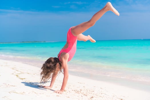 Adorable active little girl at beach during summer vacation photo