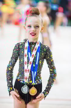 Beautiful little gymnast training on the carpet and ready for competitions photo