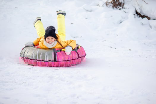 Adorable little happy girl sledding in winter snowy day. photo