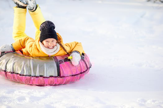 Adorable little happy girl sledding in winter snowy day. photo