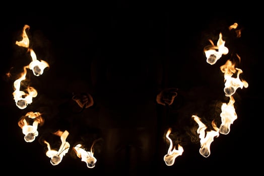 Fireshow in dark. Two steel fans with hot flames. photo